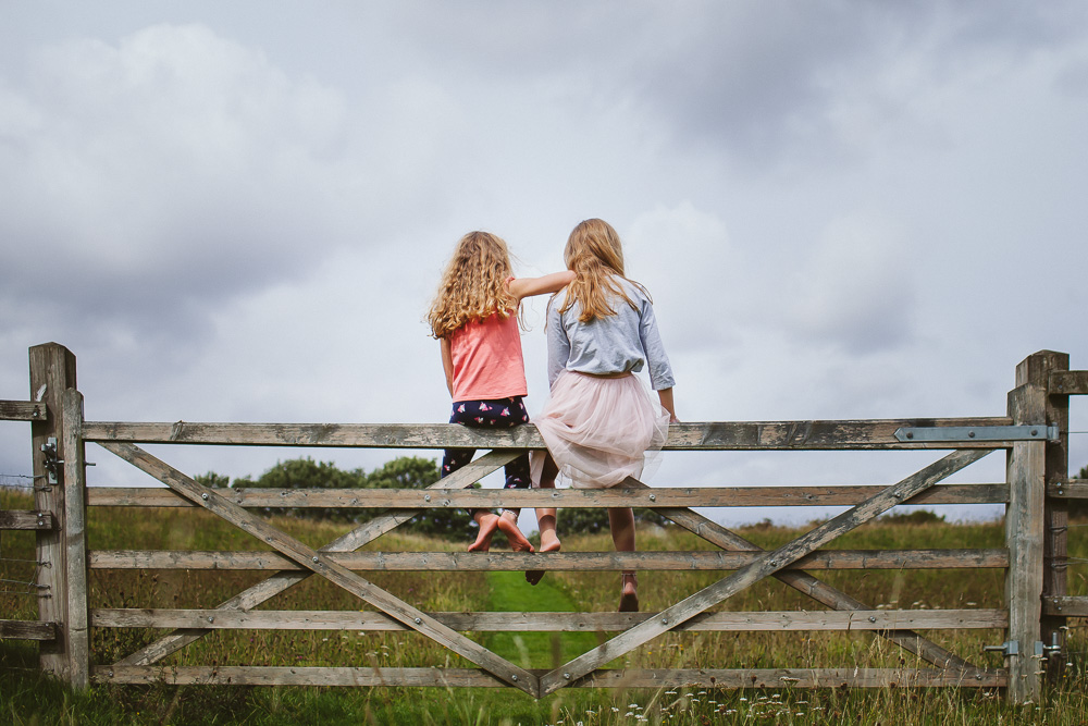 Sisters Sitting on a gate